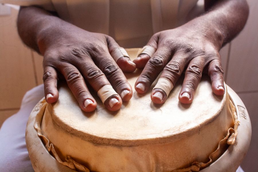 Mãos tocando um tambor de percussão